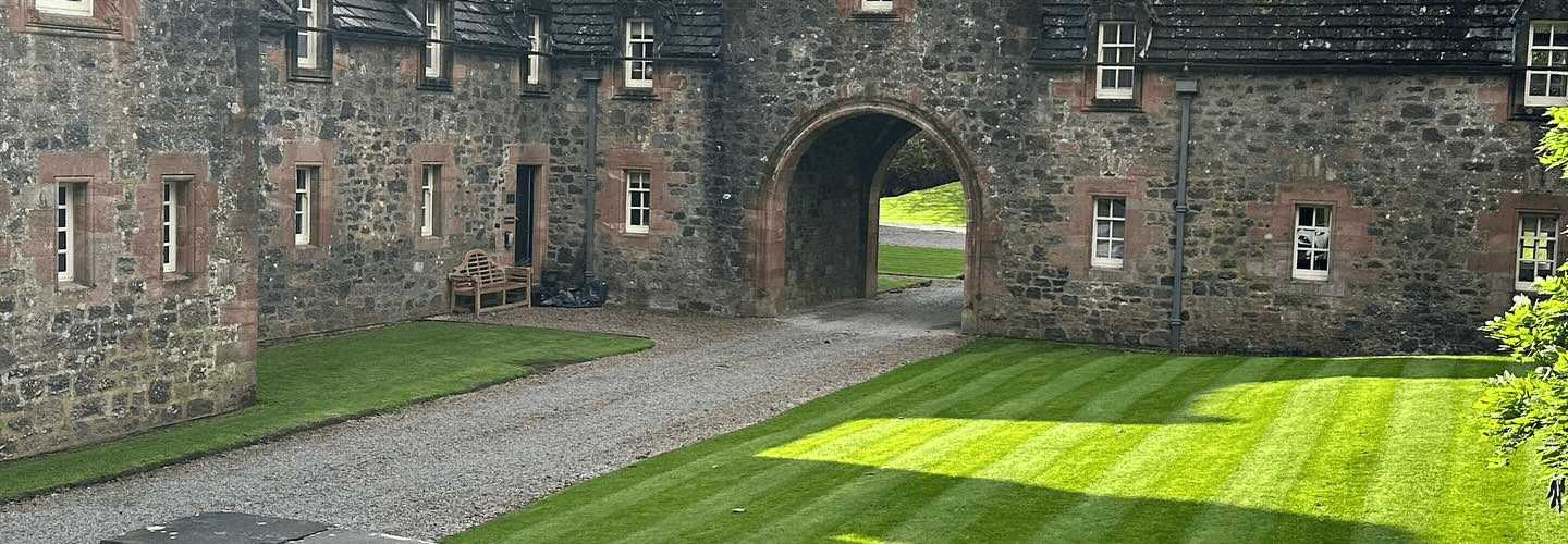 A beautiful old fashioned courtyard with grass areas to the side cut with precision